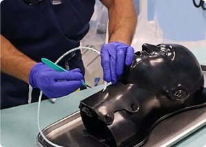 A clinician practicing a procedure on a SimKit training manikin